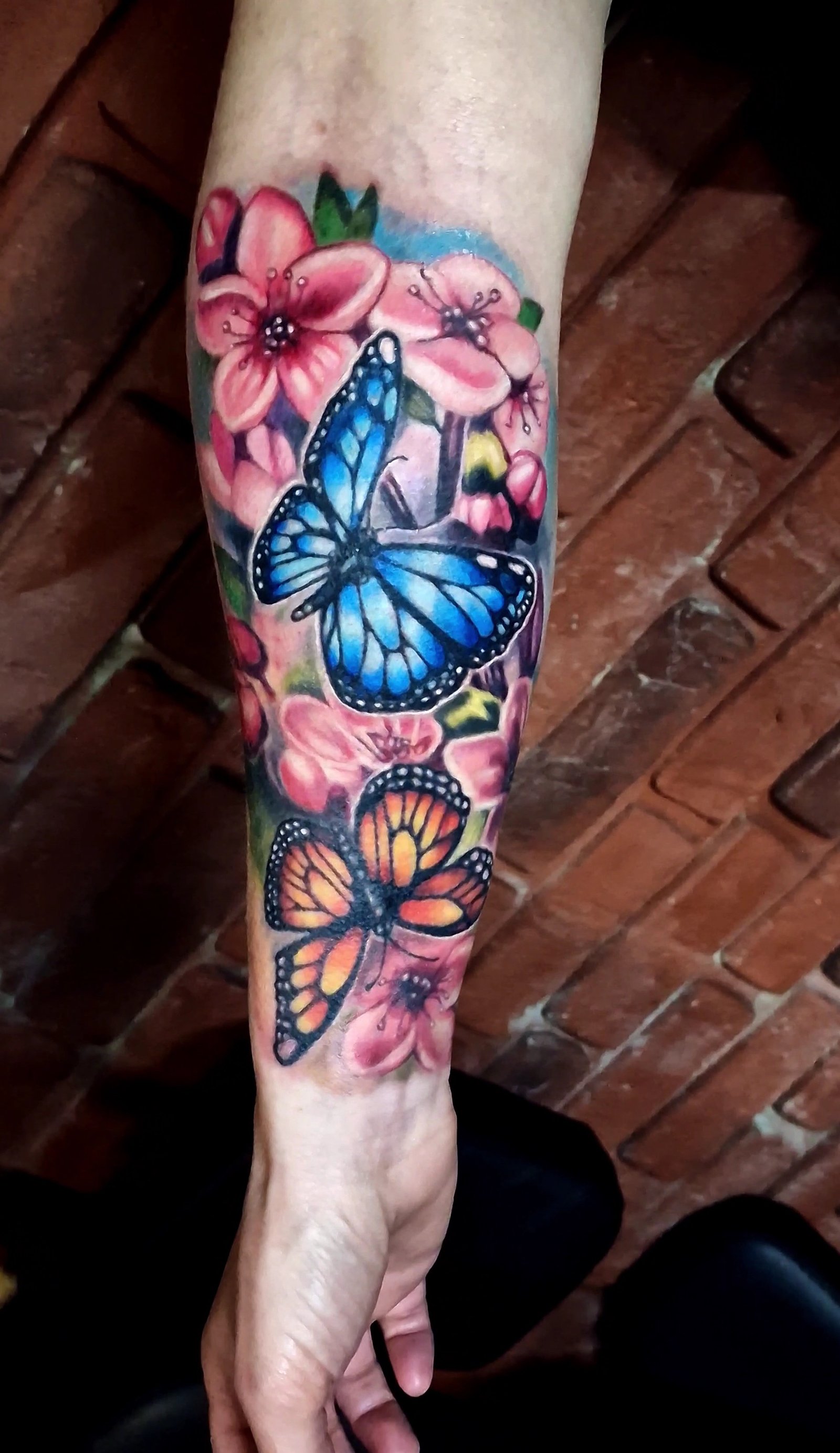 Tatouage original de fleurs et de papillons en couleurs.